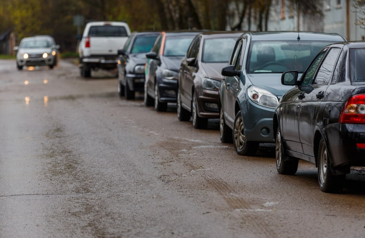 Cars parked in a row along the road.